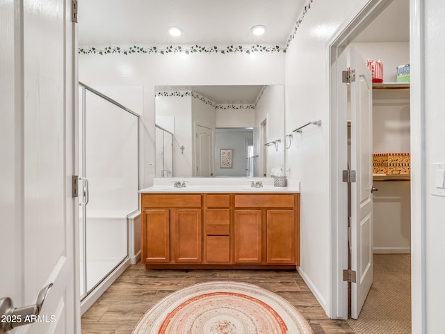 7648 S Thimble Peak, Gold Canyon, AZ 85118 - bathroom with a shower stall, wood finished floors, double vanity, a closet, and recessed lighting