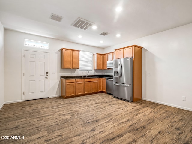 7648 S Thimble Peak, Gold Canyon, AZ 85118 - kitchen with stainless steel appliances, dark countertops, wood finished floors, a sink, and baseboards