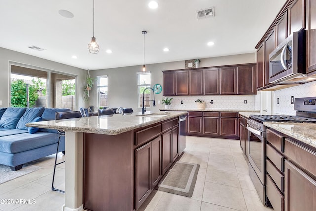 kitchen with a sink, stainless steel appliances, visible vents, and open floor plan