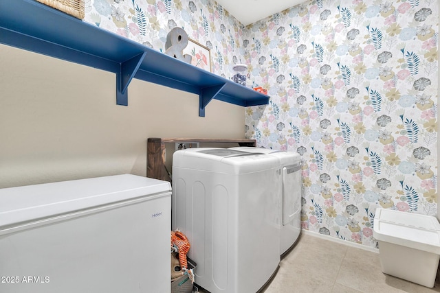 laundry room featuring washing machine and clothes dryer, light tile patterned floors, and wallpapered walls