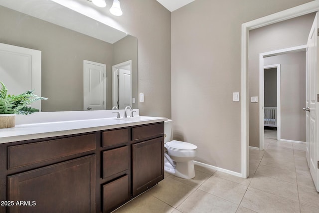 bathroom featuring baseboards, toilet, vanity, and tile patterned flooring