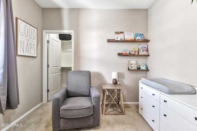 sitting room featuring light colored carpet and baseboards