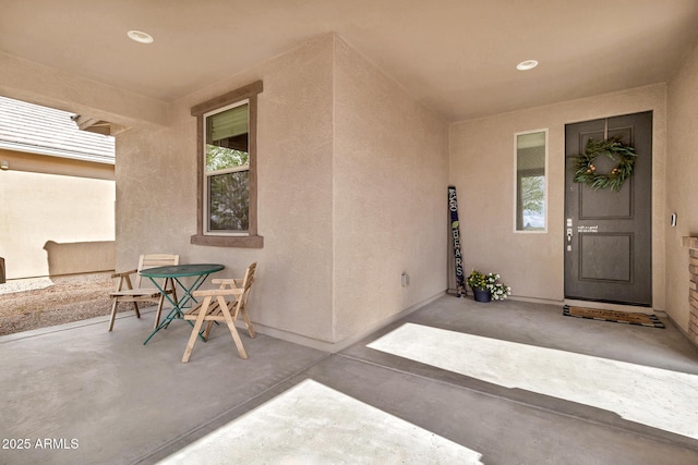 view of exterior entry with a patio area and stucco siding