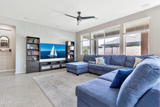 living room with light tile patterned floors, baseboards, visible vents, and ceiling fan