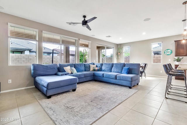 living room with light tile patterned flooring, visible vents, and baseboards