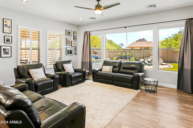 living room featuring light hardwood / wood-style flooring and ceiling fan