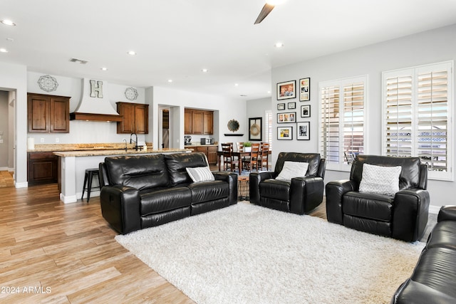 living room with ceiling fan and light hardwood / wood-style floors