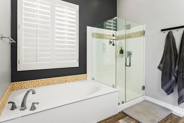 bathroom featuring wood-type flooring and shower with separate bathtub