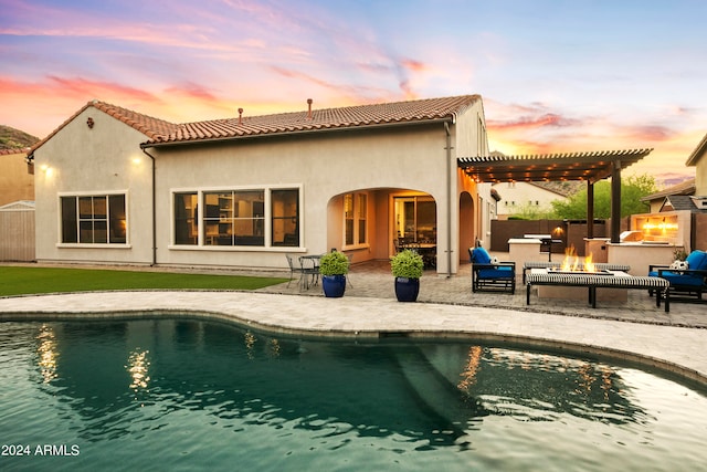 back house at dusk featuring a pergola and a patio