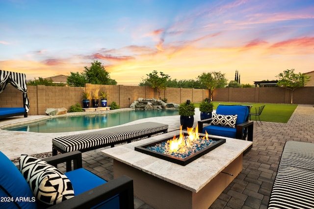 pool at dusk featuring a patio area and an outdoor fire pit