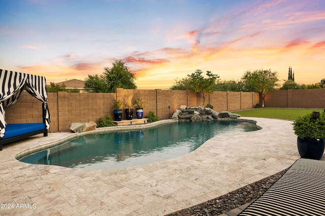 pool at dusk featuring a patio