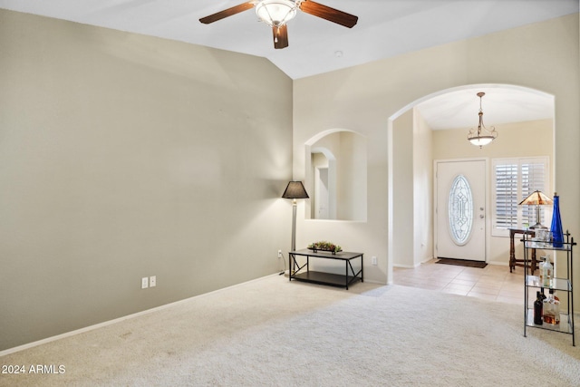 carpeted foyer entrance featuring vaulted ceiling and ceiling fan