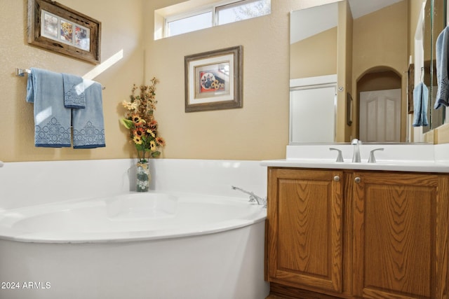 bathroom with vanity and a tub