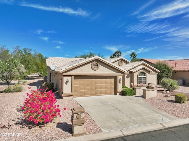 single story home featuring central air condition unit and a garage