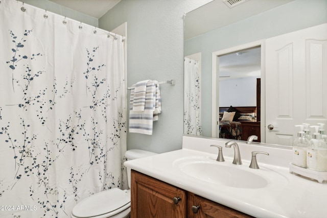 bathroom with vanity, curtained shower, and toilet