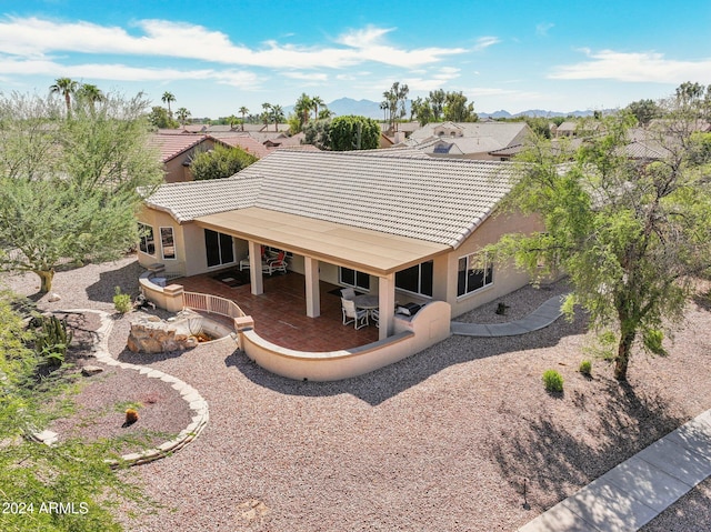 rear view of property featuring a patio area and a mountain view