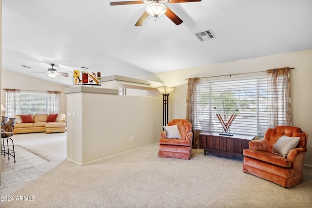 living area featuring vaulted ceiling, light colored carpet, and a healthy amount of sunlight