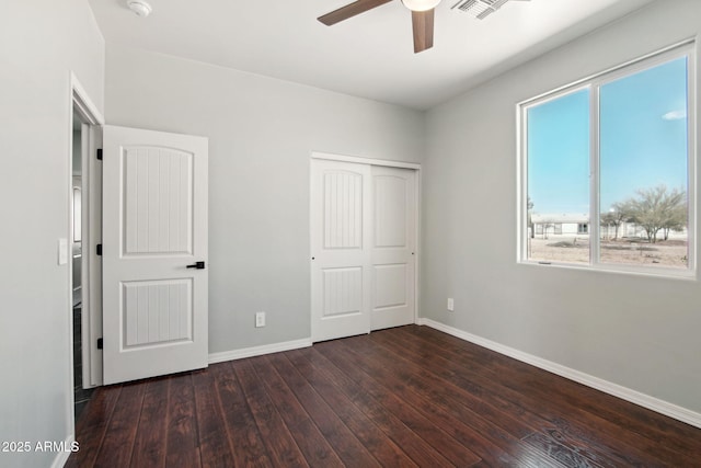 unfurnished bedroom with a ceiling fan, a closet, baseboards, and hardwood / wood-style floors