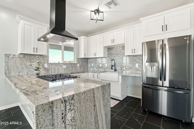 kitchen featuring black gas stovetop, island range hood, a sink, visible vents, and stainless steel refrigerator with ice dispenser