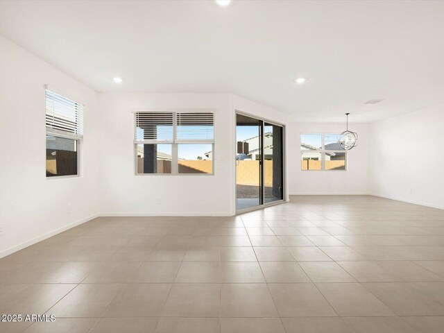 unfurnished room with a chandelier