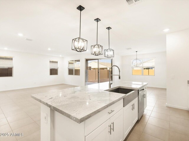 kitchen with white cabinetry, dishwasher, hanging light fixtures, light stone counters, and a kitchen island with sink