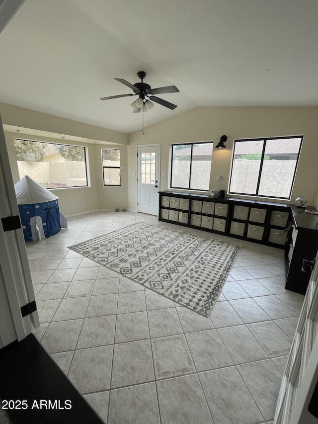 unfurnished living room with light tile patterned flooring, a ceiling fan, and vaulted ceiling