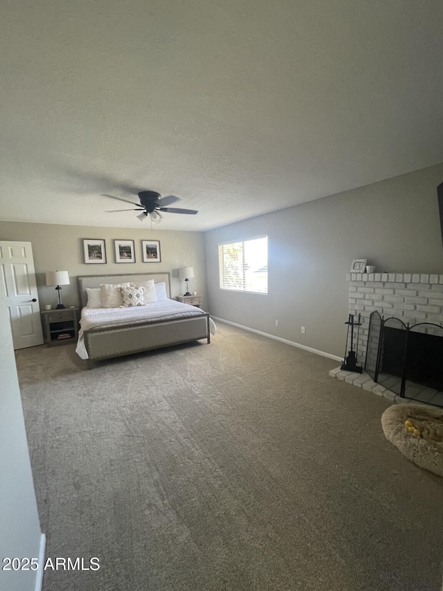 unfurnished bedroom with baseboards, carpet floors, a brick fireplace, and ceiling fan