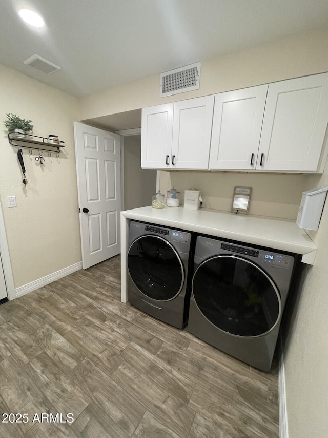 laundry room with visible vents, cabinet space, baseboards, and washing machine and dryer