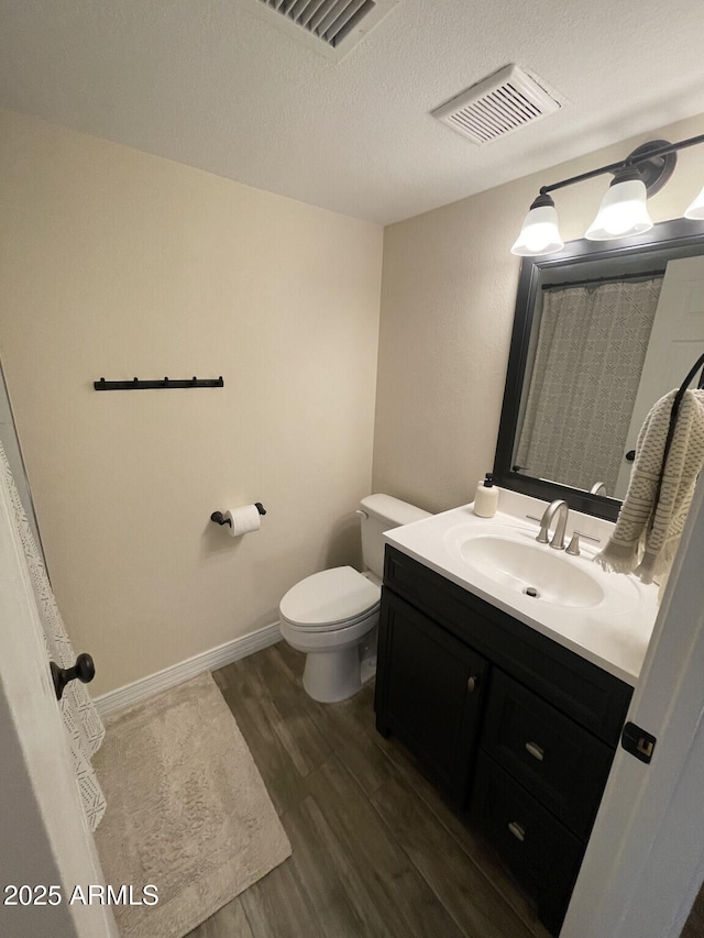 full bathroom with visible vents, toilet, wood finished floors, and vanity