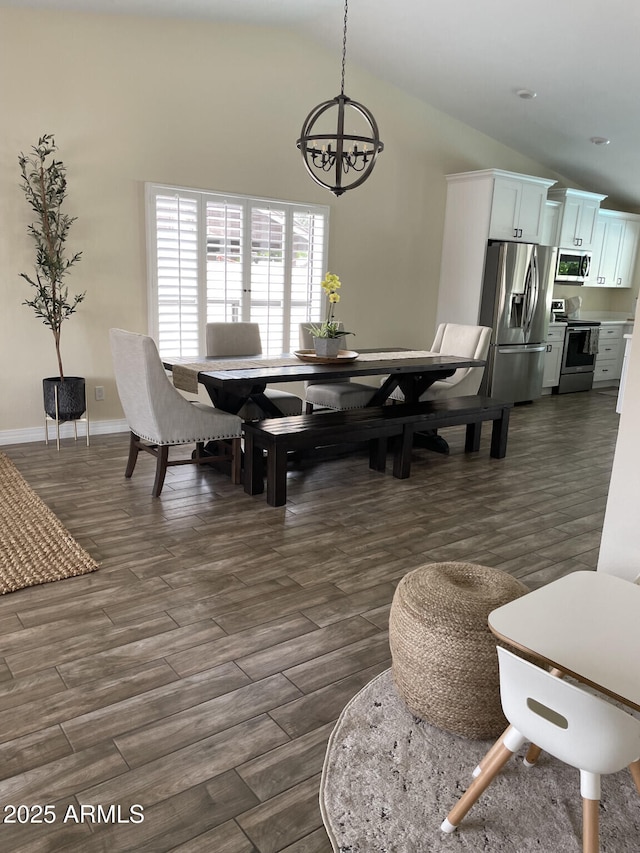 dining room with baseboards, lofted ceiling, a notable chandelier, and dark wood finished floors