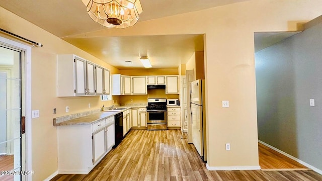 kitchen featuring white appliances, a sink, light wood-style flooring, light countertops, and a chandelier