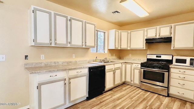 kitchen with stainless steel range with gas stovetop, black dishwasher, white microwave, under cabinet range hood, and a sink