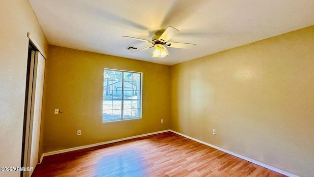 empty room featuring light wood-style floors, baseboards, and a ceiling fan