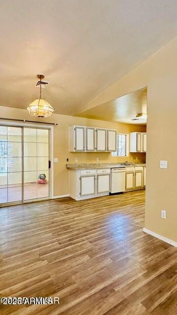 kitchen featuring white dishwasher, baseboards, light wood-style floors, and white cabinetry