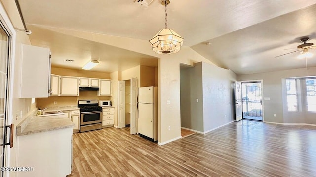 kitchen with white appliances, light wood-style floors, light countertops, vaulted ceiling, and baseboards