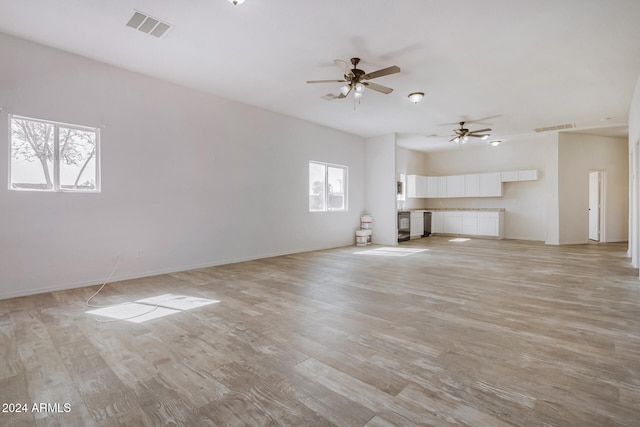 unfurnished living room with ceiling fan, a wealth of natural light, and light hardwood / wood-style floors