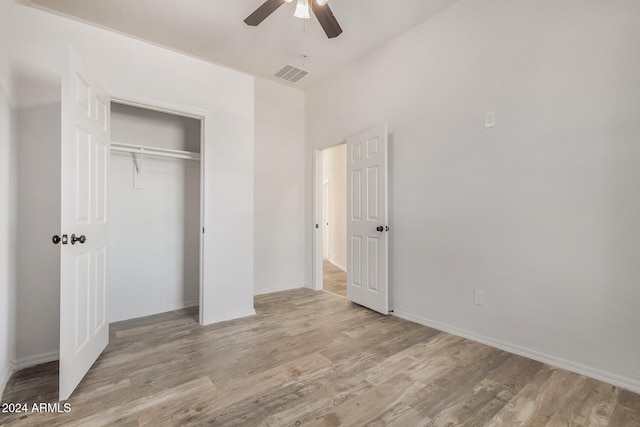 unfurnished bedroom featuring a closet, light wood-type flooring, and ceiling fan