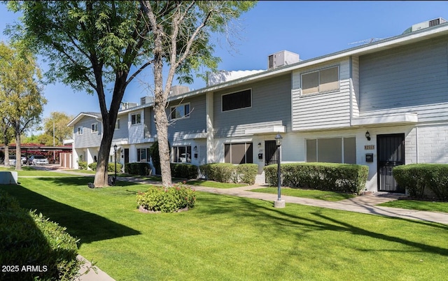 back of property featuring a residential view and a lawn