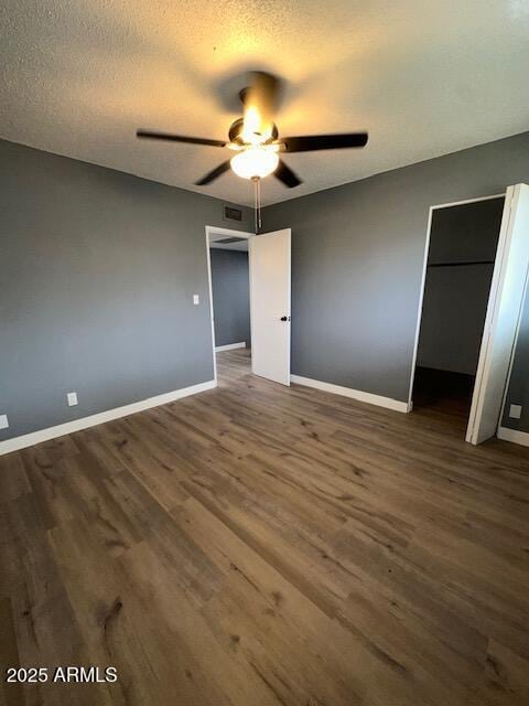 unfurnished bedroom with ceiling fan, a textured ceiling, baseboards, and wood finished floors