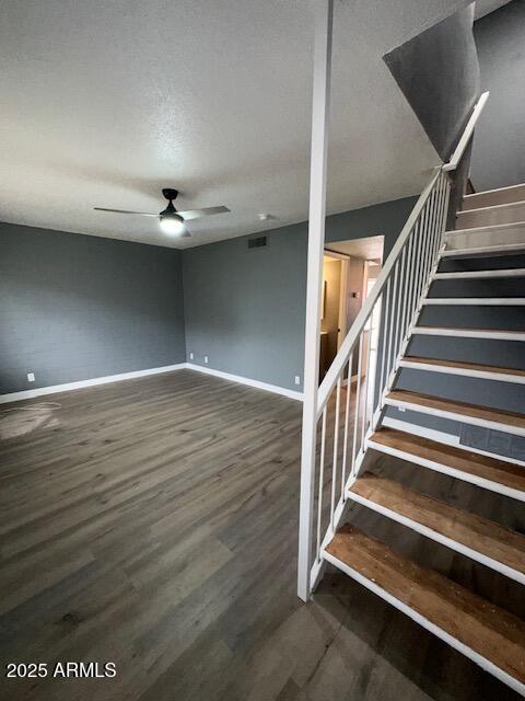 interior space with ceiling fan, visible vents, baseboards, and wood finished floors