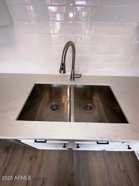 interior details with light stone countertops and a sink