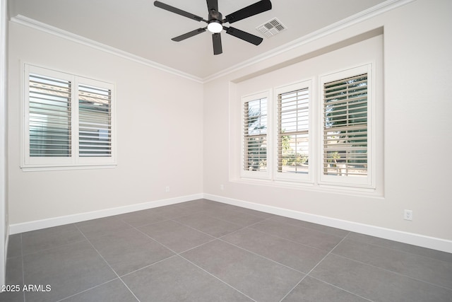 unfurnished room with ornamental molding, plenty of natural light, dark tile patterned flooring, ceiling fan, and baseboards