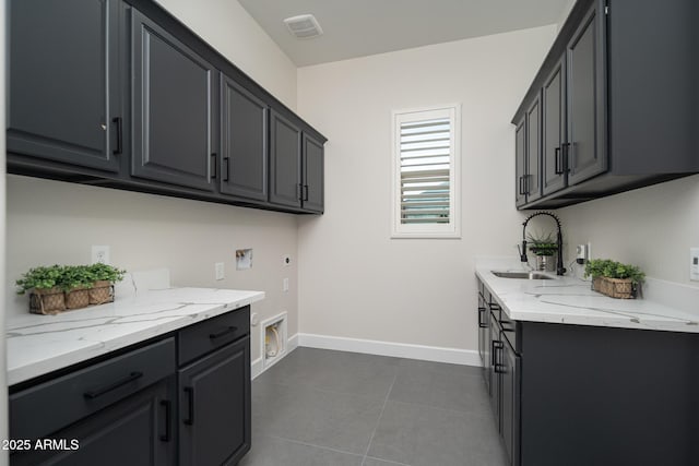 washroom featuring cabinet space, hookup for an electric dryer, hookup for a washing machine, dark tile patterned flooring, and baseboards