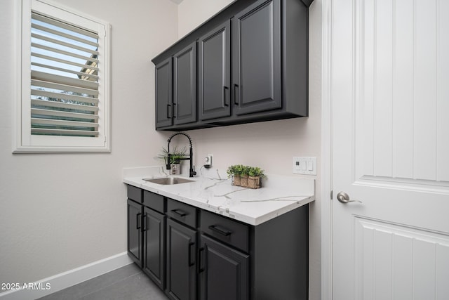laundry room featuring a sink, baseboards, and tile patterned flooring