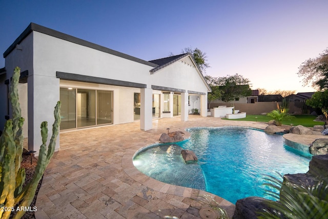pool at dusk featuring a patio and a fenced backyard