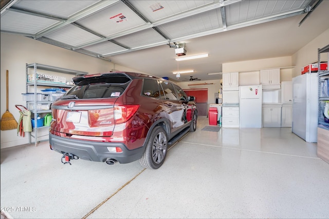 garage with white refrigerator, fridge, and a garage door opener