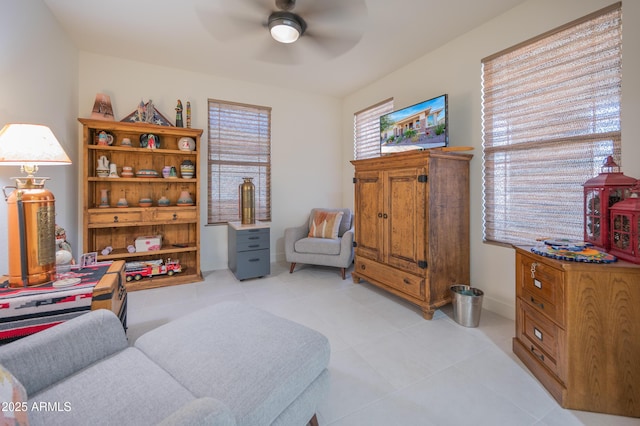 living area with light tile patterned flooring and ceiling fan