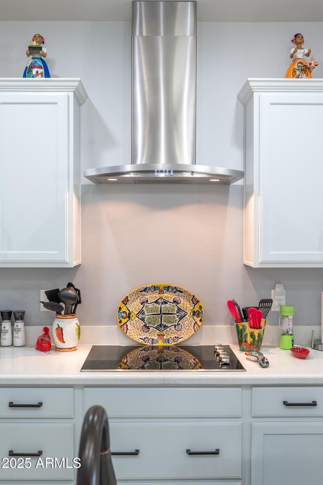 kitchen featuring white cabinets, black electric stovetop, and exhaust hood