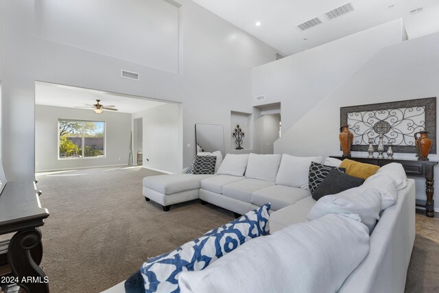 carpeted living room featuring ceiling fan and high vaulted ceiling