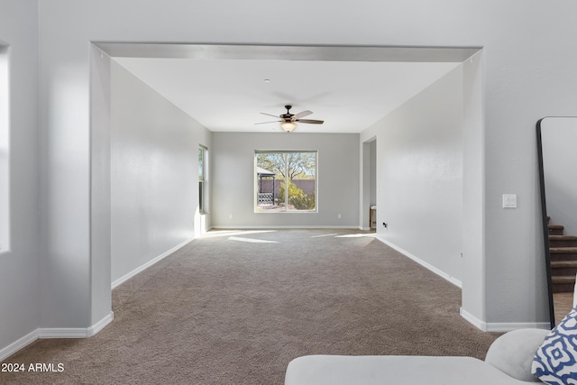 unfurnished living room with carpet and ceiling fan